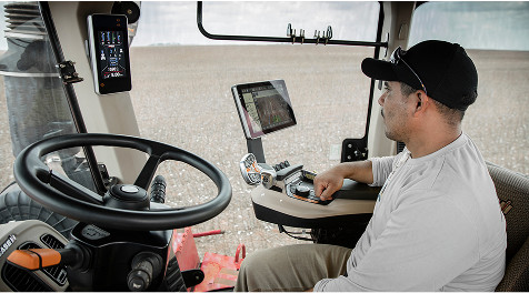 Operador de colheitadeiras dentro da cabine de uma Axial-Flow Case IH realizando uma colheita